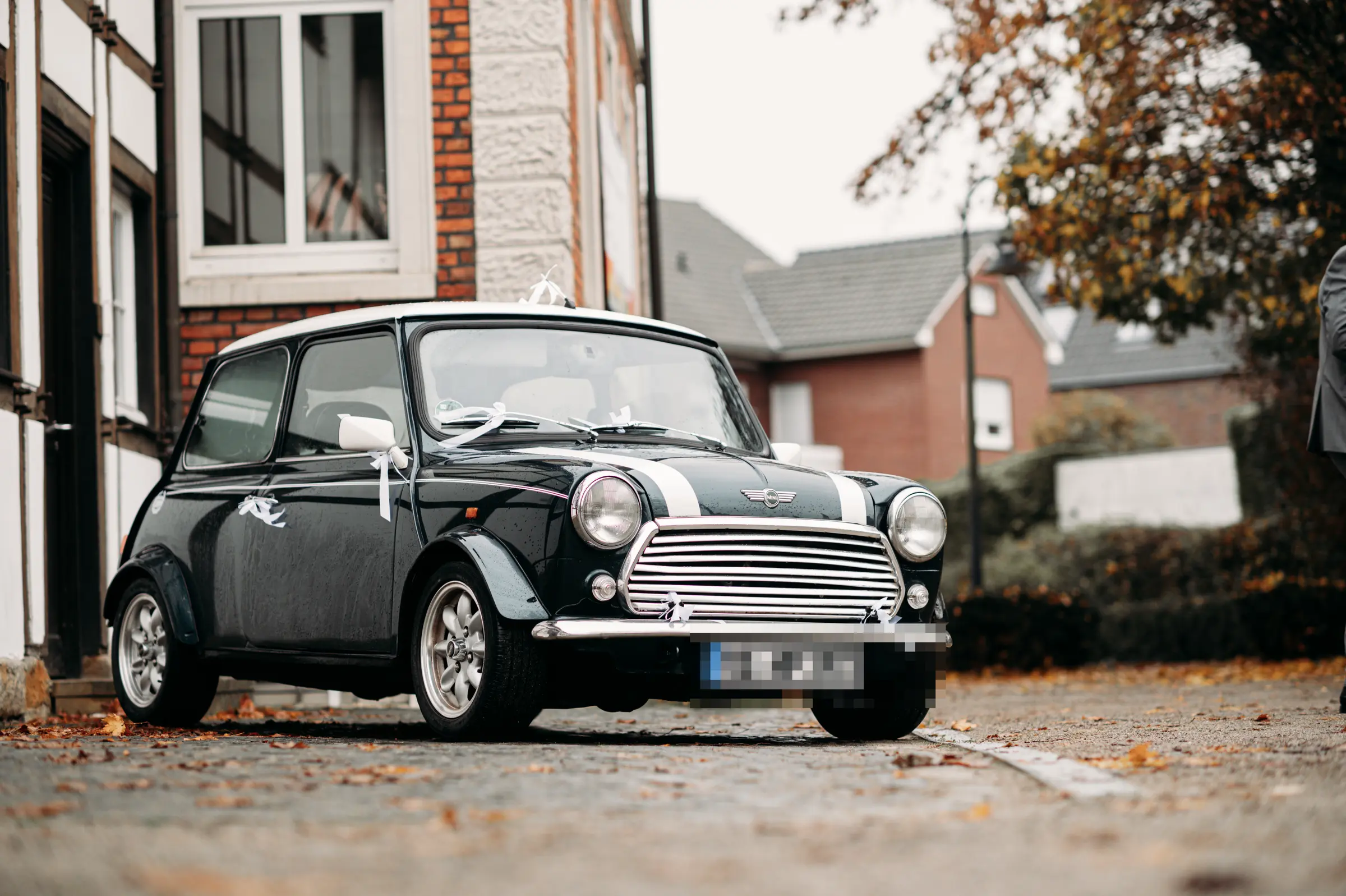 Historischer Mini Cooper, festlich mit weißen Bändern für die Hochzeit geschmückt