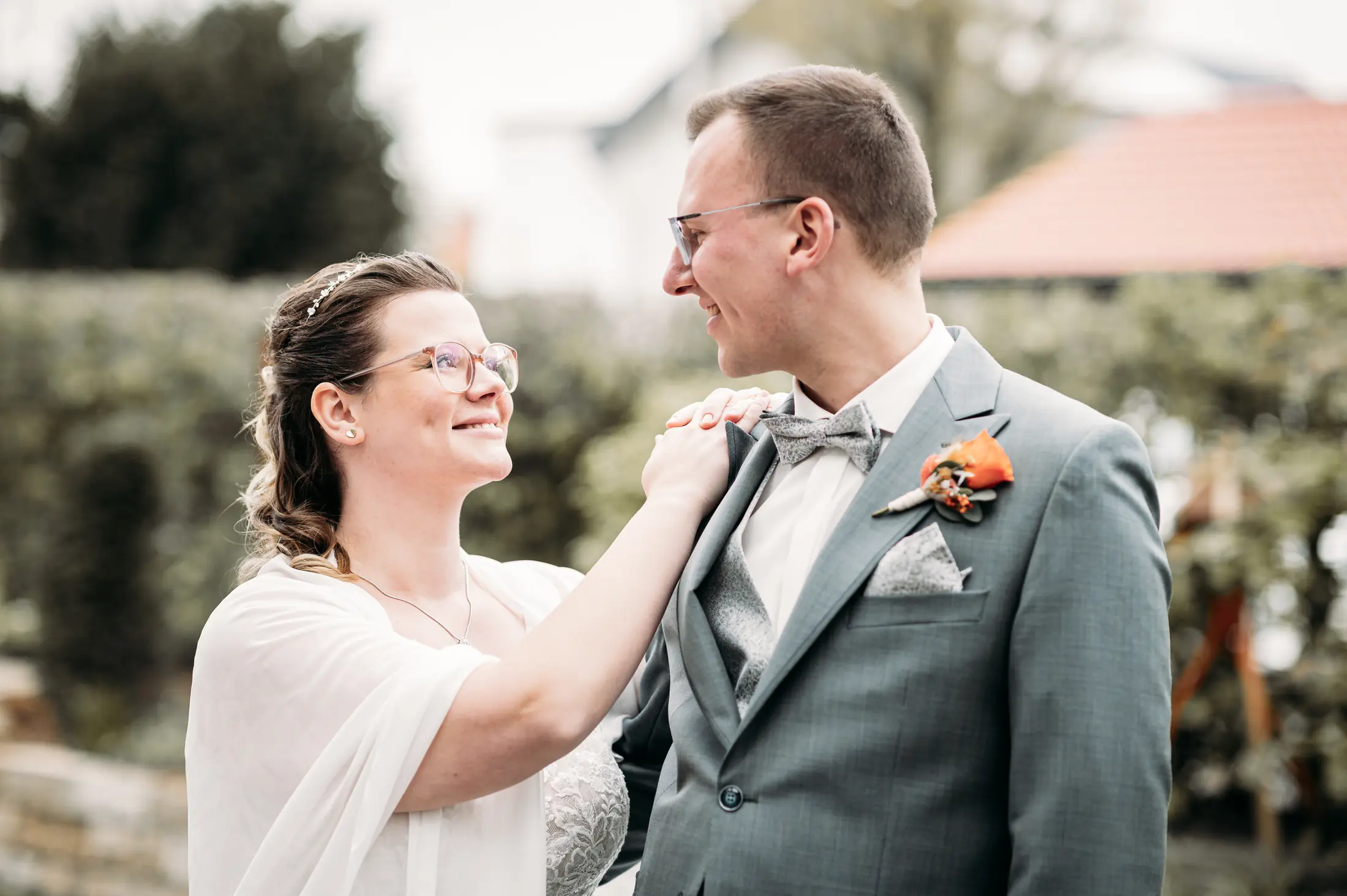Marina legt Jannik beim First Look im Garten liebevoll die Hand auf die Schulter, beide lächeln sich an