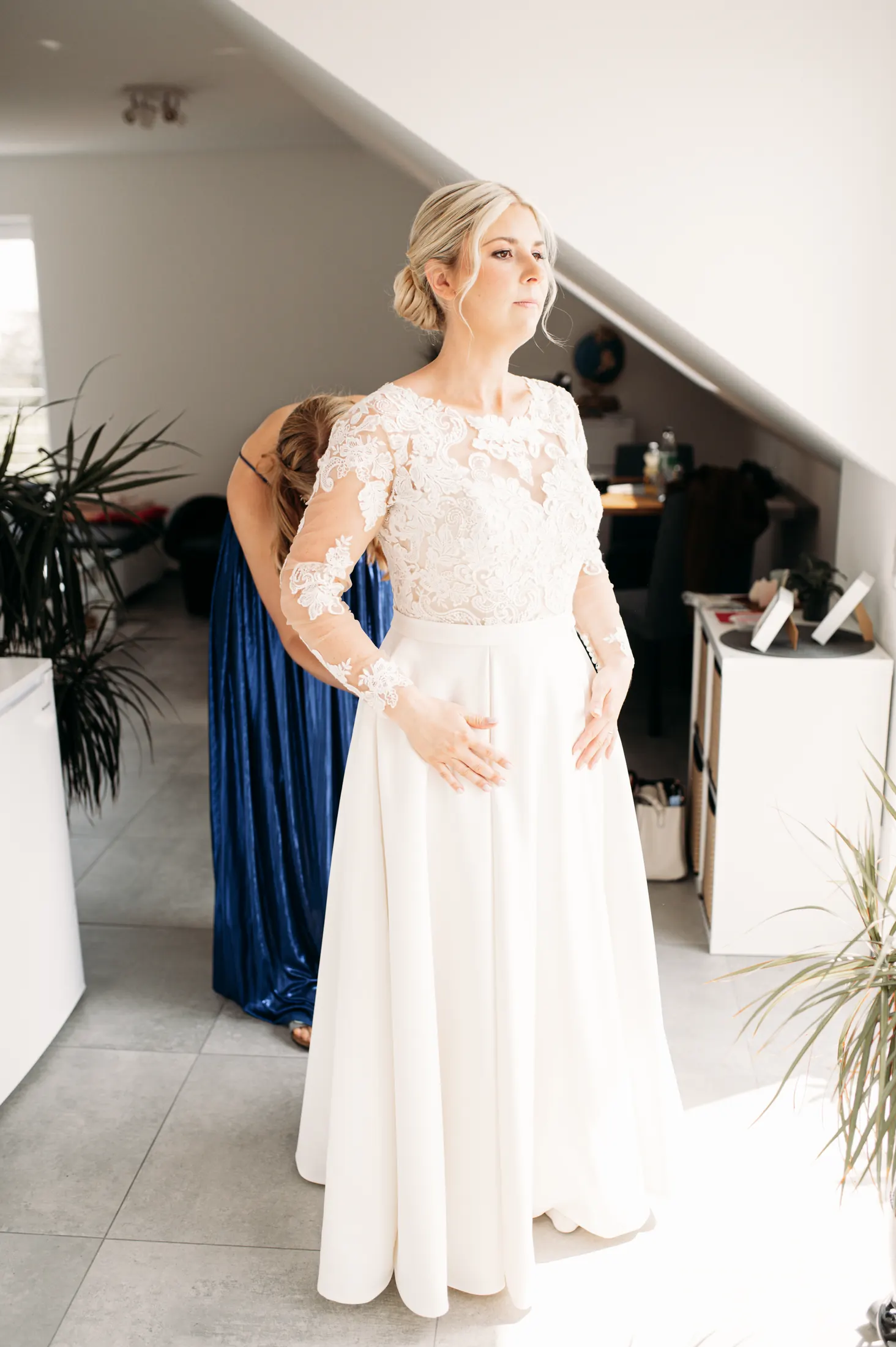 Viktoria wird im Dachgeschoss beim Anziehen des Brautkleides geholfen
