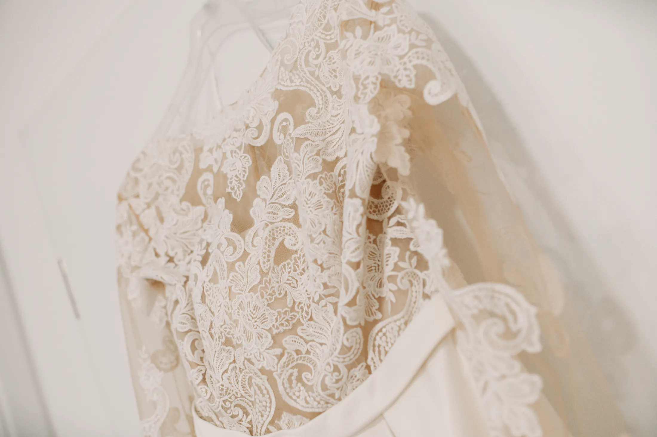 Detailaufnahme der floralen Spitzenärmel von Viktorias Brautkleid am Bügel