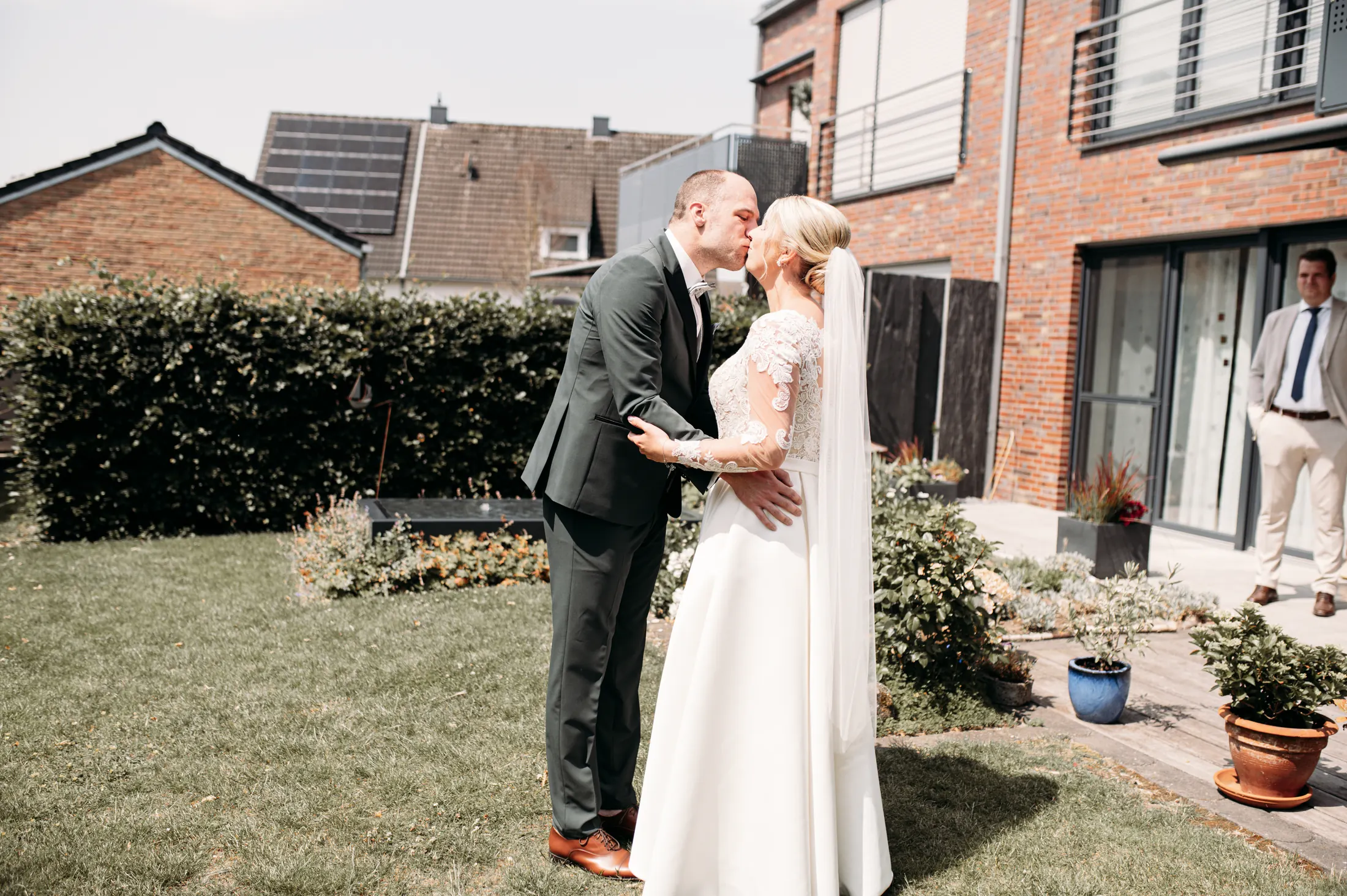Tobias und Viktoria küssen sich beim First Look im heimischen Garten