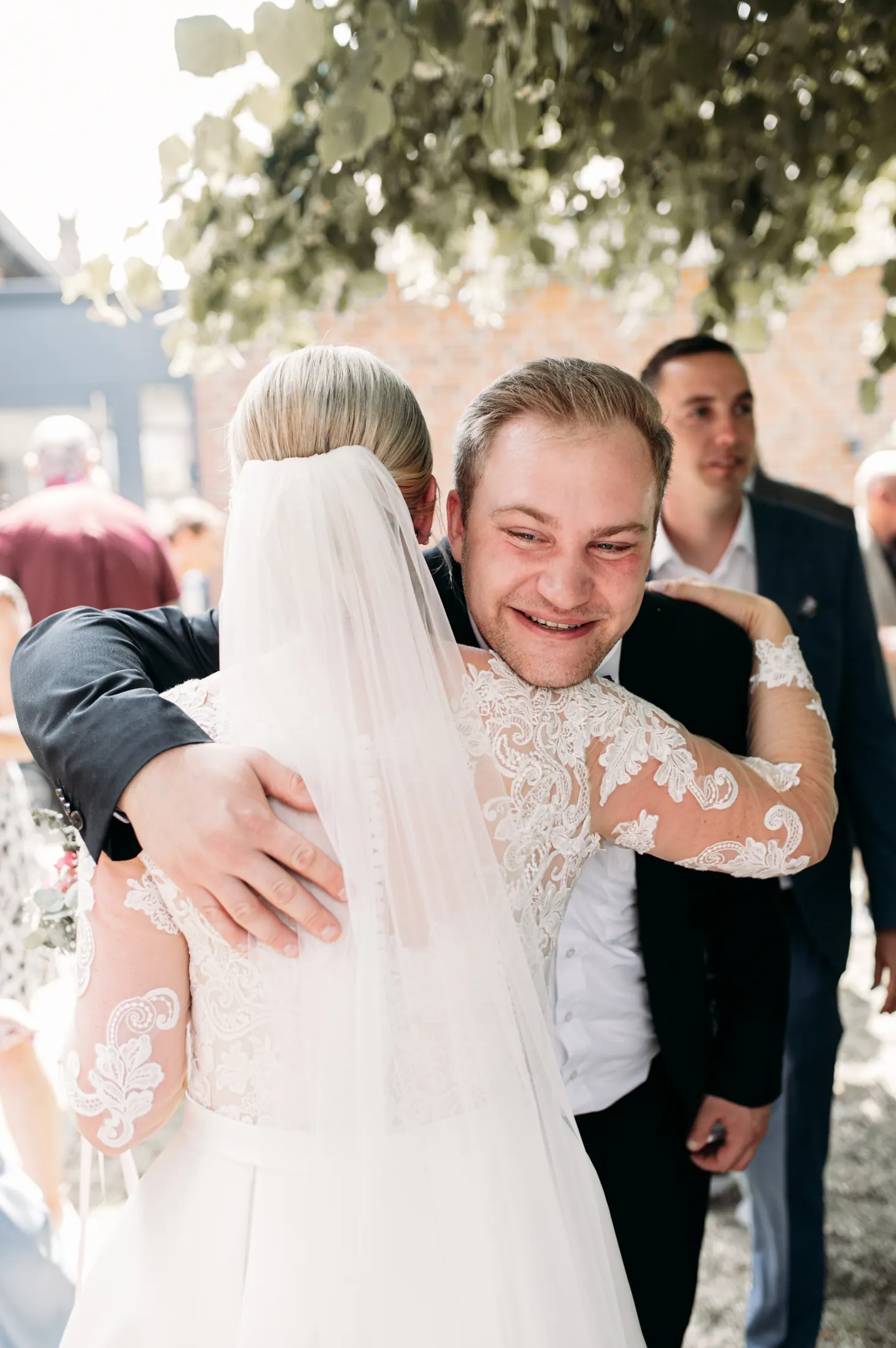 Ein Gast umarmt Viktoria herzlich zur Gratulation nach der Trauung